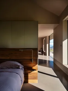 A modern bedroom with a brown concrete floor and minimalist design.