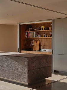 A modern residential kitchen with a granite countertop and wood cabinetry.