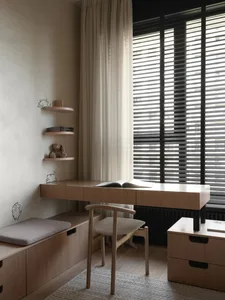 A modern minimalist home office space featuring wooden furnishings and materials.
