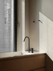 Modern bathroom with concrete sink, wooden countertop, and minimalist design
