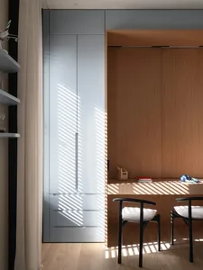 A minimalist workstation with wooden materials featuring a white cabinet and clean lines.