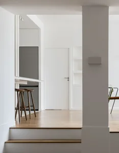 A modern apartment featuring a minimalist tech room with white materials.