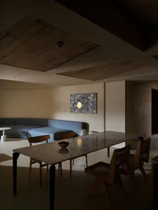 A sleek, modern dining room with a marble table and wooden chairs.