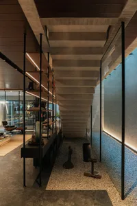 Modern industrial interior featuring a concrete staircase with open risers and a glass railing.