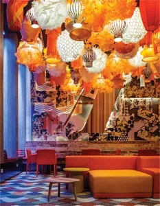A brightly lit hotel lounge featuring colorful cushions, decorative lighting, and a vibrant atmosphere.
