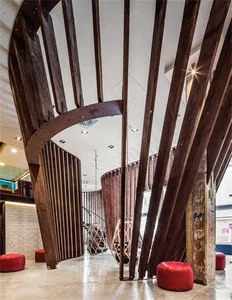 A modern office space with exposed wooden beams and a geometric staircase.