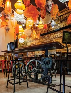 An industrial-themed restaurant interior with metal, wood, concrete, and fabric elements.