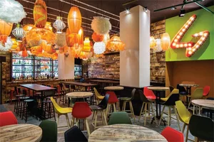Industrial-style restaurant featuring wood, metal, and plastic furniture and decor elements.