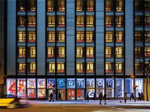 Modern building facade featuring illuminated glass windows and concrete columns.