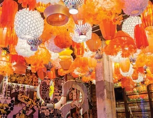Colorful fabric lanterns and paper sculptures hanging from the ceiling.