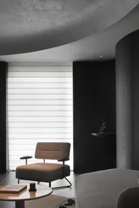 Modern living room with black walls, minimalist design, and white window blinds.