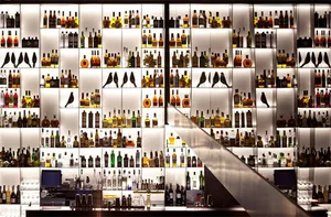 Well-stocked bar interior with bottles and glassware.