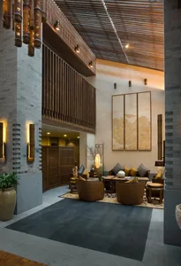 Modern hotel lobby with concrete flooring, wooden walls, and marble accents.