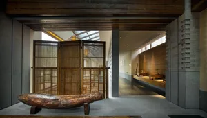 A serene spa interior featuring a minimalist wooden bench and natural lighting through skylights.