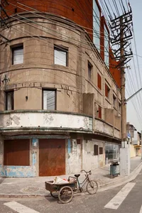 A street corner with an old building facade in a concrete alley with electric wires