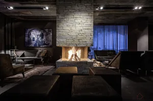 A modern industrial living room featuring a stone fireplace