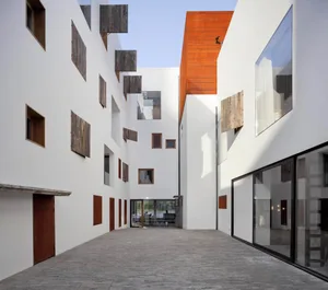 Modern architectural design featuring a glass facade and white walls.