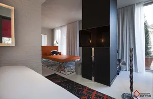 A modern bedroom featuring minimalist design with concrete, glass, and metal elements.