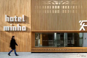 A modern hotel entrance with wooden cladding and glass doors.