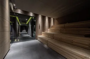 Interior view of a modern industrial spa room with wooden seating and minimalist design.