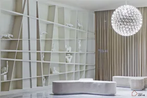 A modern living room featuring an abstract panel with wire-frame design and decorative sculptures. White and metallic tones a