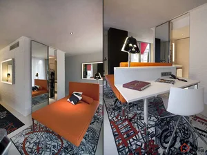 Modern living room featuring an orange fabric couch, white walls, and a geometric rug.