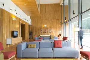 A modern living room with wooden walls and blue furniture.