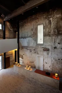 Urban industrial residential interior with concrete walls and exposed beams.