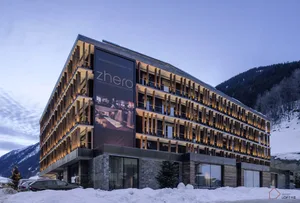 Modern hotel exterior featuring wood, stone, and glass.