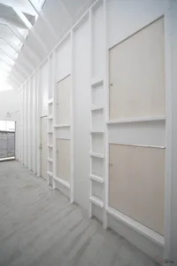 A minimalist bedroom with a concrete floor and walls.