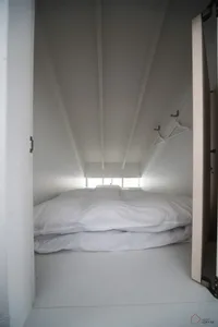 White bedding on a bed in a minimalist modern loft bedroom