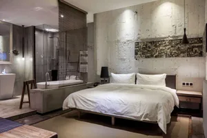 Modern industrial-style bedroom with concrete walls and minimalist furniture.