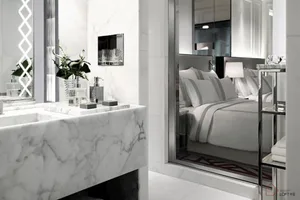 Minimalist bedroom featuring marble surfaces and luxurious bedding.