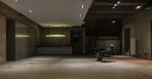 A minimalist empty loft with concrete walls and a wooden floor.
