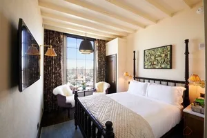 A stylish bedroom featuring modern anthropological design elements with wood and plaster