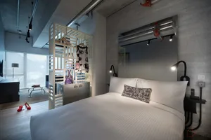 Photograph of a modern bedroom with concrete and wooden materials.
