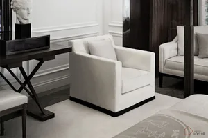 A modern bedroom featuring a white upholstered armchair with textured fabric, placed against a minimalist backdrop with a con