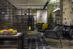 Modern interior design of a hotel reception area with metal, wood, and fabric materials.