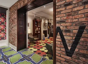 A modern living room features brick walls and a patterned floor.