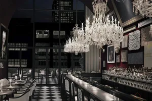 A luxurious restaurant bar with glass chandeliers and contemporary design elements.