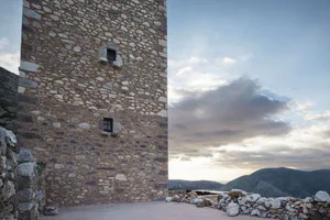 A stone tower building with a cloudy sky in the background.