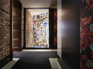 Modern entrance hall featuring a glass-enclosed mosaic wall.