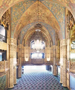 A grand interior space with ornate painted arches and columns.