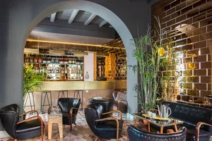 Industrial-style bar with brick walls, metal accents, and glass shelves