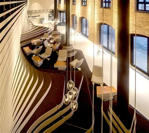 Modern industrial co-working space featuring metal and glass furniture against a brick wall