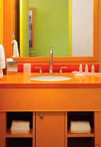 Minimalist bathroom with an orange countertop and white sink.