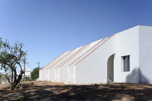 Modern architectural exterior with white stucco facade and sloped roof.