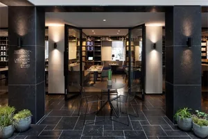 A modern coffee shop with black marble floors and black chairs.
