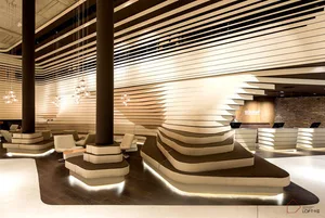 Modern interior design reception area with concrete walls, reception desks, and chandeliers at resort.