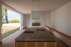 A modern kitchen with a marble countertop and a view of the outdoors.